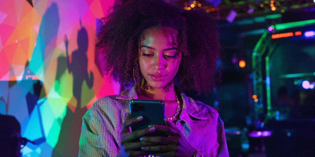 Junger Influencer mit Smartphone in stylischer Umgebung.