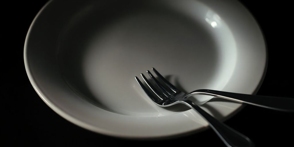 Leeres Teller mit Besteck auf dunklem Hintergrund.