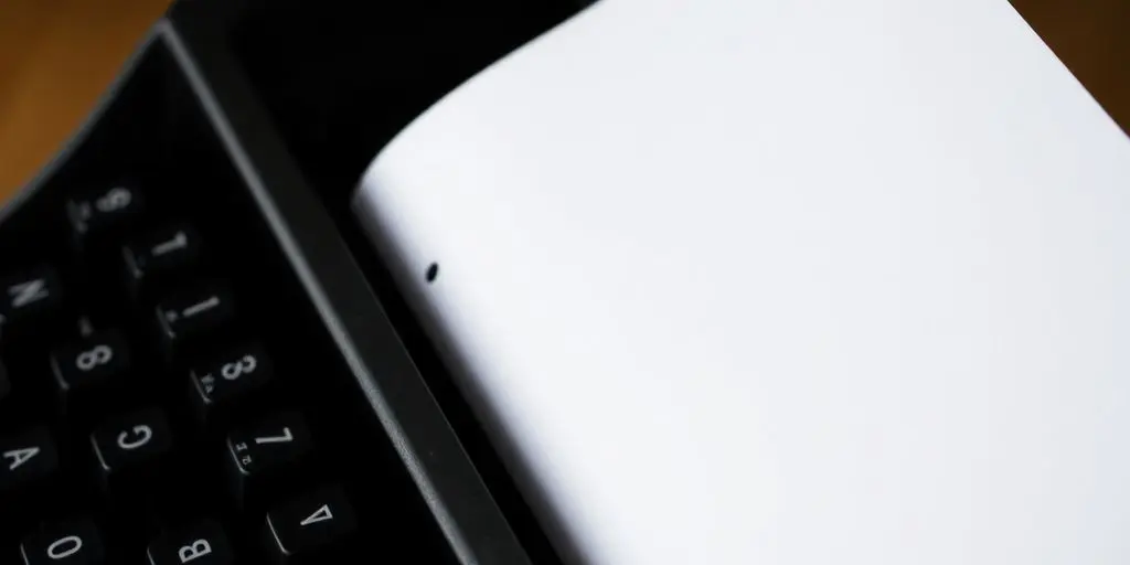 Nahaufnahme einer Schreibmaschine mit leerem Blatt Papier.